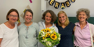 Ute Tietz, Dagmar Slickers, Kaja Subellok (mit einem Blumenstrauß in der Hand), Ilka Winterfeld und Jutta Cornelißen-Weghake nebeneinander stehend in einem Seminarraum