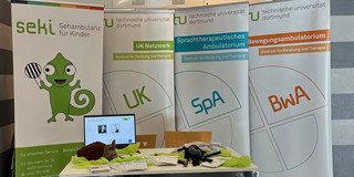 Kontakttag 2024 Stand Foto eines Infostandes, Tisch mit Infomaterial und vier Aufsteller im Hintergrund von seki, UK, SpA und BwA